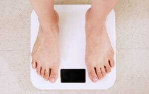 person standing on white digital bathroom scale